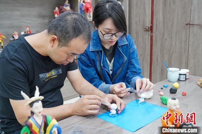 <a target='_blank'  data-cke-saved- >中新社</a>記者(右)現(xiàn)場體驗(yàn)面塑制作過程?！￡悹帍?qiáng) 攝