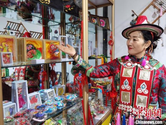 圖為身著民族服飾的隴原巧手展示手工藝品。(資料圖) 徐雪 攝