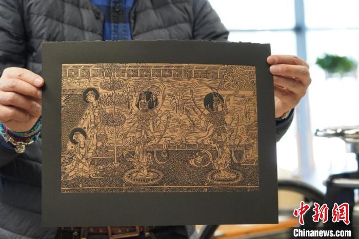 圖為手工書(shū)藝人展示敦煌雕版壁畫(huà)印刷品?！【琶赖┰?　攝