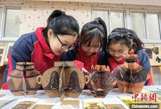 圖為學(xué)生用紙創(chuàng)作的立體彩陶?！⒂裉?攝