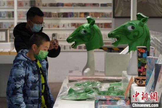 圖為“神馬來了”銅奔馬頭套吸引參觀者駐足?！【琶赖┰?攝