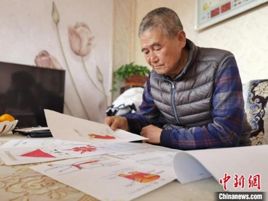 圖為陸鵬飛向記者展示多年帶隊(duì)的手寫筆記?！堟?攝