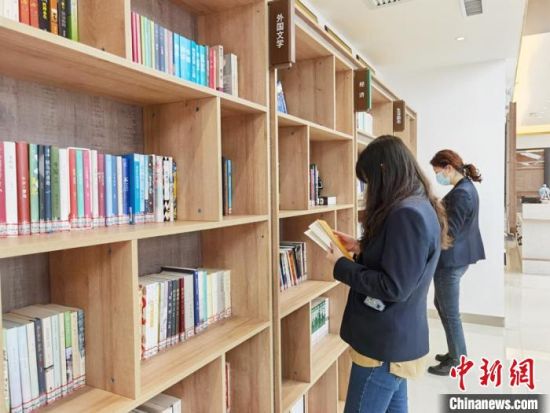 圖為在甘肅公航旅建設(shè)集團有限公司的職工書屋，職工挑選書籍?！⌒煅?攝
