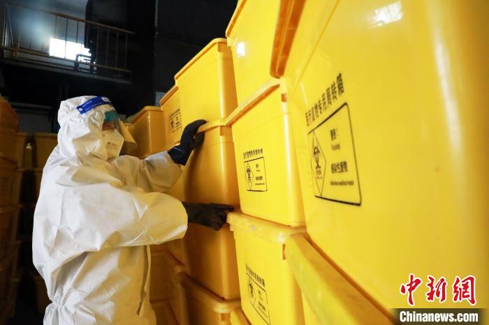 圖為工作人員搬運(yùn)醫(yī)療廢物專用周轉(zhuǎn)箱?！∥航ㄜ?攝