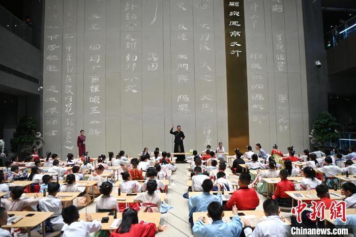 圖為9月7日，甘肅簡(jiǎn)牘博物館開(kāi)館儀式在蘭州舉行，小朋友們學(xué)習(xí)書(shū)寫(xiě)簡(jiǎn)牘中的文字?！≈行律缬浾?九美旦增 攝