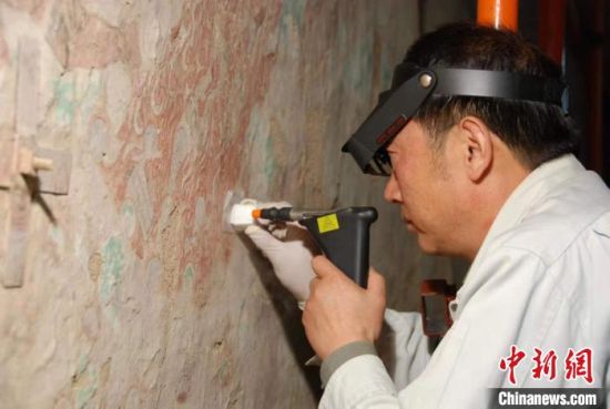 敦煌研究院研究員樊再軒進行壁畫修復(fù)。(資料圖)張云文 攝