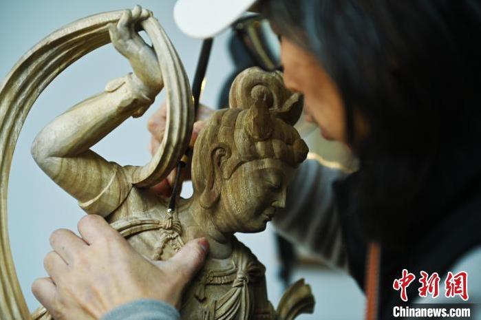 圖為季茂杰進(jìn)行敦煌元素的木雕創(chuàng)作。李亞龍 攝</p>
<p>