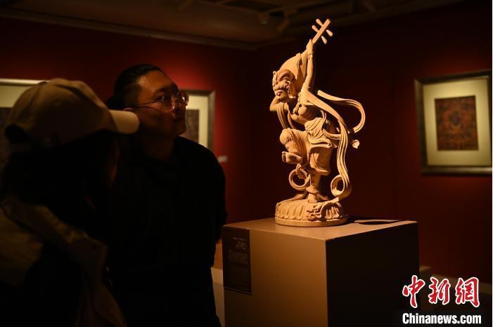 圖為季茂杰向參觀者介紹自己創(chuàng)作敦煌木雕的過(guò)程。李亞龍 攝</p>
<p>