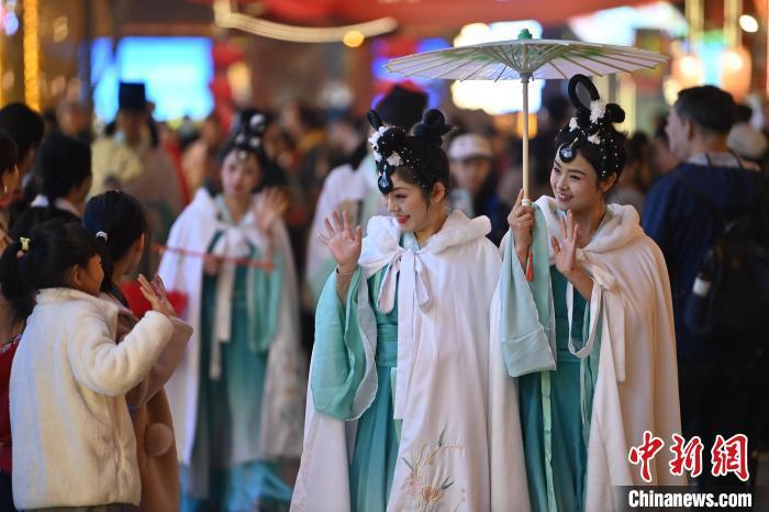 圖為街區(qū)人員著傳統(tǒng)服飾與游人互動。李亞龍 攝</p><p>