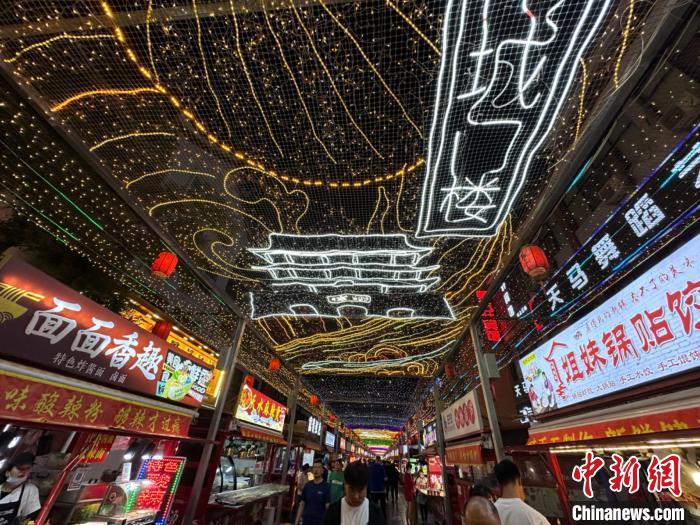 圖為明清街夜市燈光點(diǎn)亮具有武威文化元素的“涼州古城門(mén)”彩燈?！〈魑牟?攝</p><p>