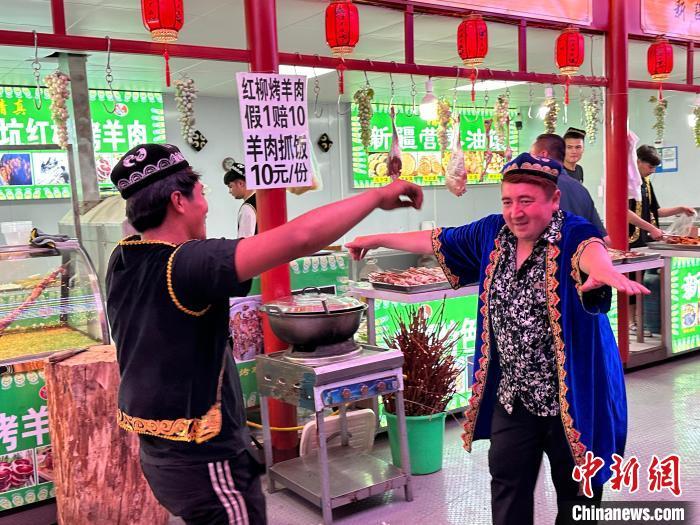 圖為餐飲經(jīng)營(yíng)者在“西涼不夜城”跳起舞蹈引客?！〈魑牟?攝</p><p>