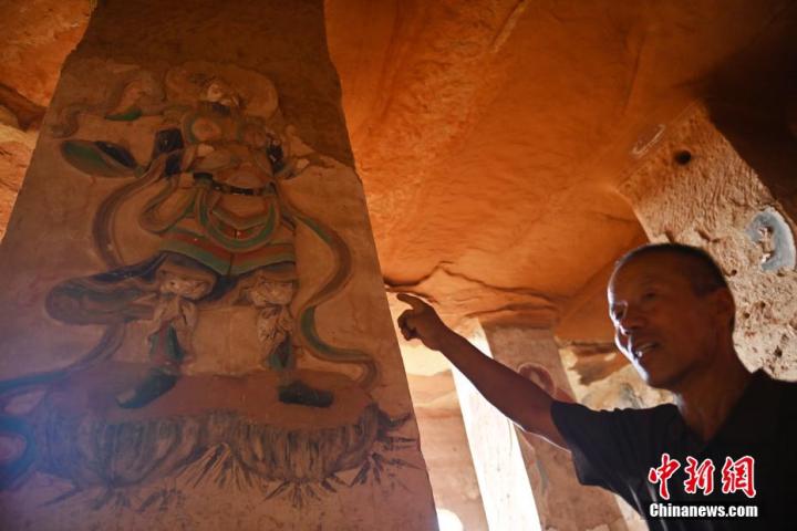 7月15日，甘肅省平涼市涇川縣百里石窟長廊羅漢洞石窟內，該窟文保員郭建平介紹窟內石刻彩繪壁畫。郭建平家中三代人曾自發(fā)保護羅漢洞石窟。羅漢洞石窟遺存40余個窟龕，以北魏至清代風格為主。中新社記者 李亞龍 攝</p>
<p>