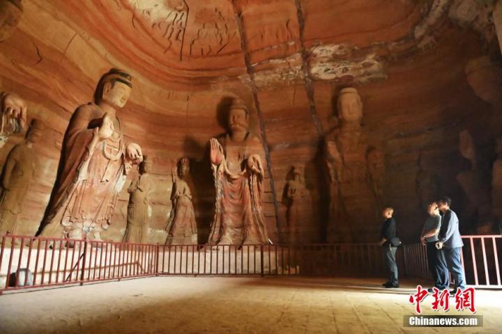 7月15日，游人參觀甘肅省平涼市涇川縣百里石窟長廊中的南石窟寺1號窟。百里石窟長廊位于涇川縣境內，由512個石窟、5眼窟中石井組成，現存王母宮石窟、鳳凰山石窟、南石窟寺、丈八寺石窟、羅漢洞石窟、太山寺石窟等規(guī)模較大的石窟群，還有數量眾多的小石窟群。南石窟寺開鑿于北魏永平三年，其中1號窟屬于大型七佛窟，七佛高達6米。中新社記者 李亞龍 攝