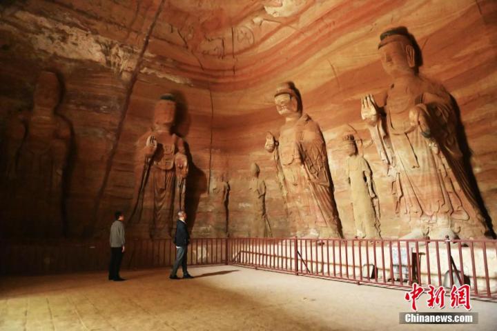 7月15日，游人參觀甘肅省平涼市涇川縣百里石窟長廊中的南石窟寺1號窟。百里石窟長廊位于涇川縣境內，由512個石窟、5眼窟中石井組成，現存王母宮石窟、鳳凰山石窟、南石窟寺、丈八寺石窟、羅漢洞石窟、太山寺石窟等規(guī)模較大的石窟群，還有數量眾多的小石窟群。南石窟寺開鑿于北魏永平三年，其中1號窟屬于大型七佛窟，七佛高達6米。中新社記者 李亞龍 攝