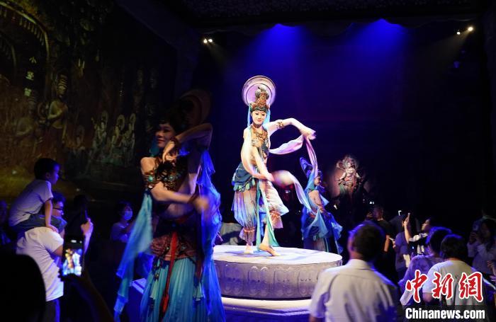 《樂(lè)動(dòng)敦煌》是全球首部洞窟式沉浸體驗(yàn)劇，利用真人與數(shù)字影像虛實(shí)交換實(shí)現(xiàn)沉浸式體驗(yàn)。圖為2023年8月28日晚，《樂(lè)動(dòng)敦煌》演出。(資料圖)中新社記者 毛建軍 攝