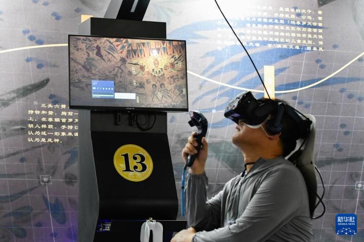 7月22日，游客借助VR設(shè)備沉浸式游覽莫高窟第285窟虛擬場景。新華社記者 郎兵兵 攝